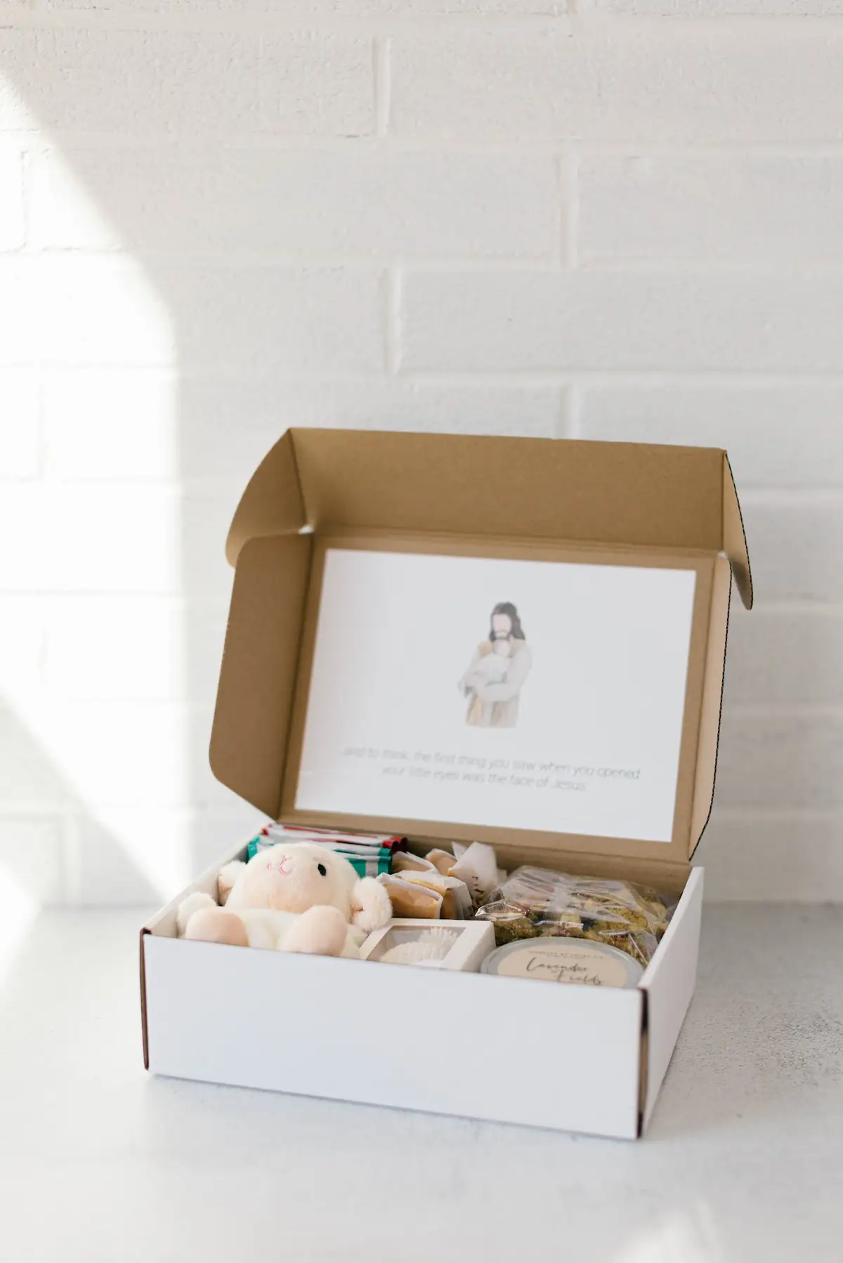 A quiet still life with a candle, tea, and soft keepsakes — gathered for a grieving family.