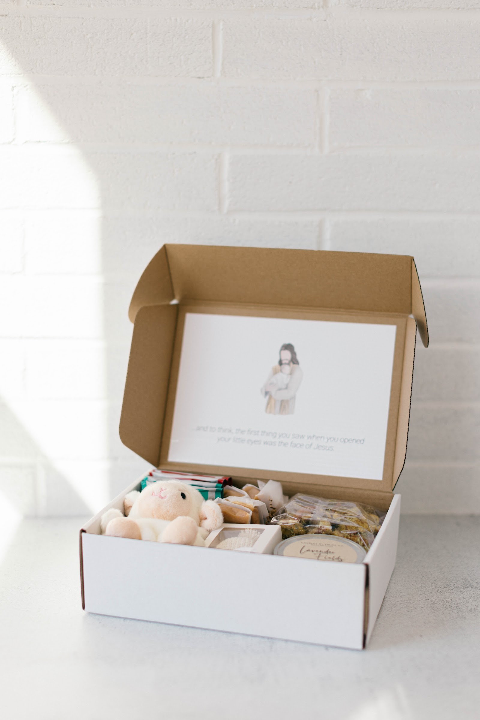 A quiet still life with a candle, tea, and soft keepsakes — gathered for a grieving family.